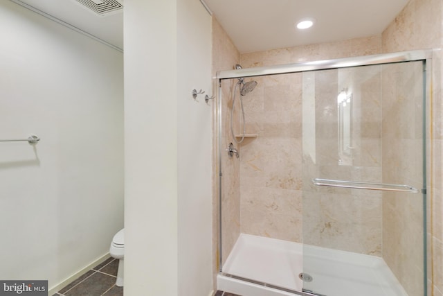 bathroom with tile patterned flooring, toilet, and walk in shower