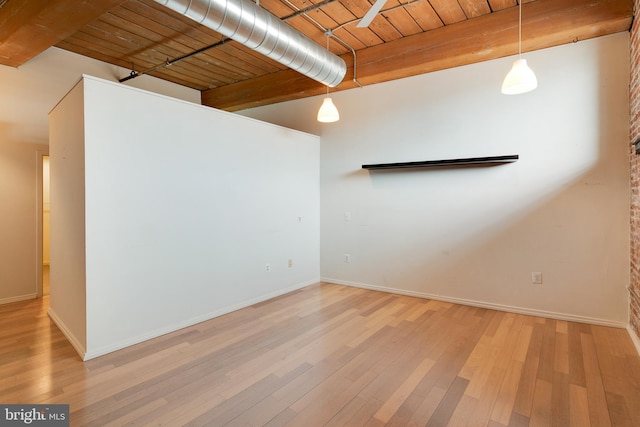 spare room with beam ceiling, hardwood / wood-style floors, and wood ceiling