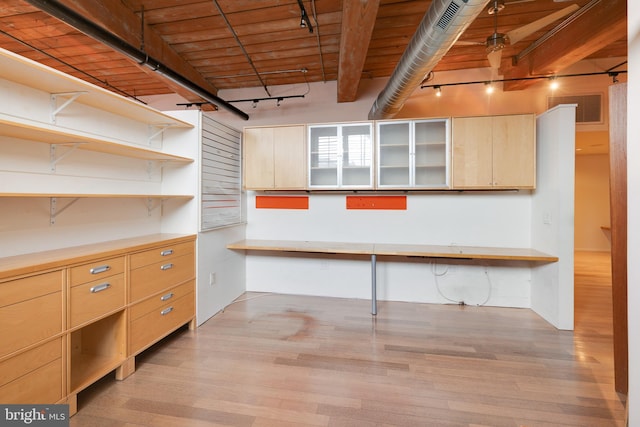 basement with rail lighting, built in desk, light hardwood / wood-style floors, and wooden ceiling