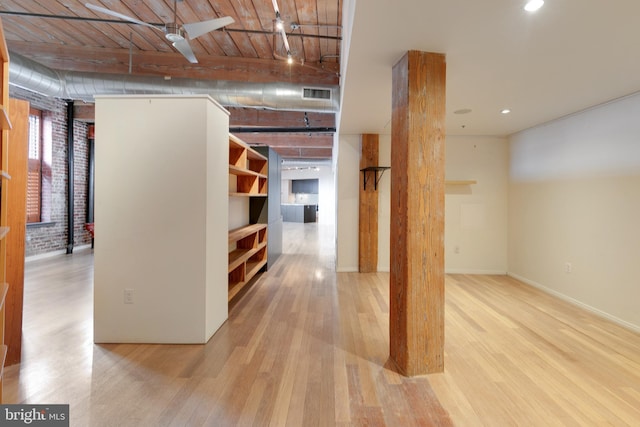 hallway featuring brick wall, wooden ceiling, and light hardwood / wood-style flooring