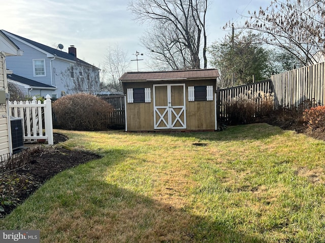 view of outdoor structure featuring cooling unit and a lawn