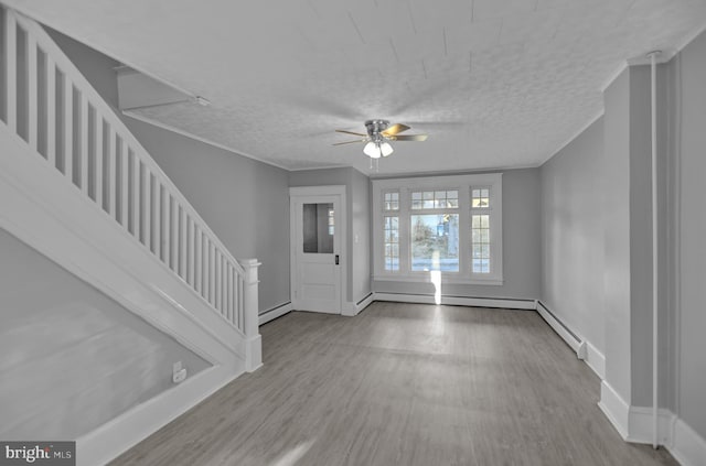 entryway featuring ceiling fan, a baseboard radiator, ornamental molding, and light hardwood / wood-style flooring