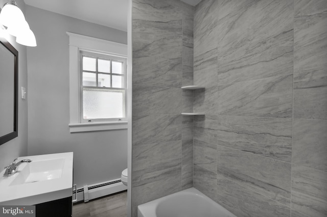 bathroom featuring hardwood / wood-style flooring, a baseboard radiator, vanity, and toilet