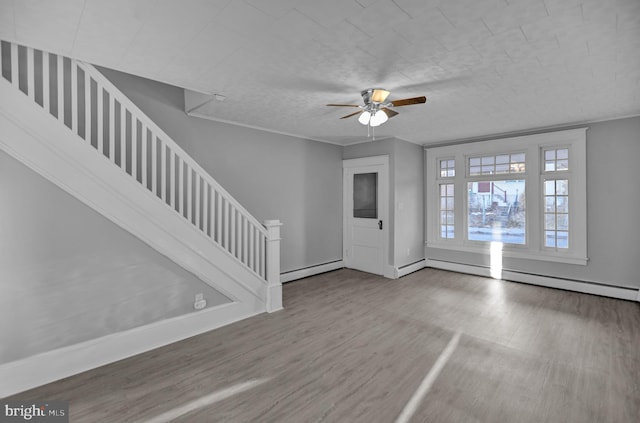 entrance foyer featuring wood-type flooring, ceiling fan, and baseboard heating