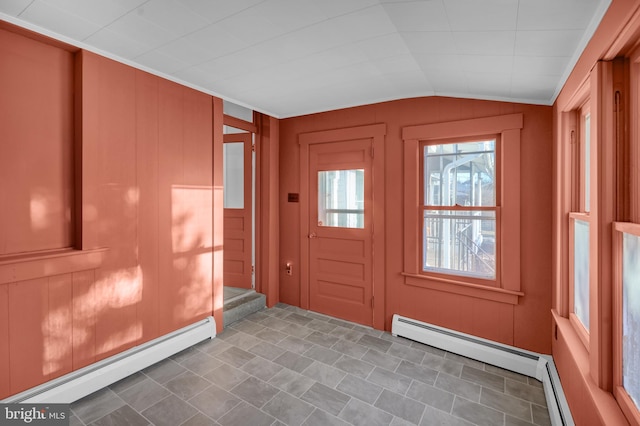 interior space featuring lofted ceiling, baseboard heating, and wood walls