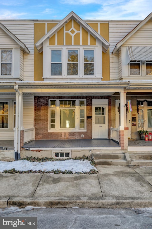 snow covered property entrance featuring covered porch