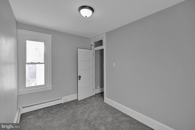 unfurnished bedroom featuring carpet floors and a baseboard heating unit