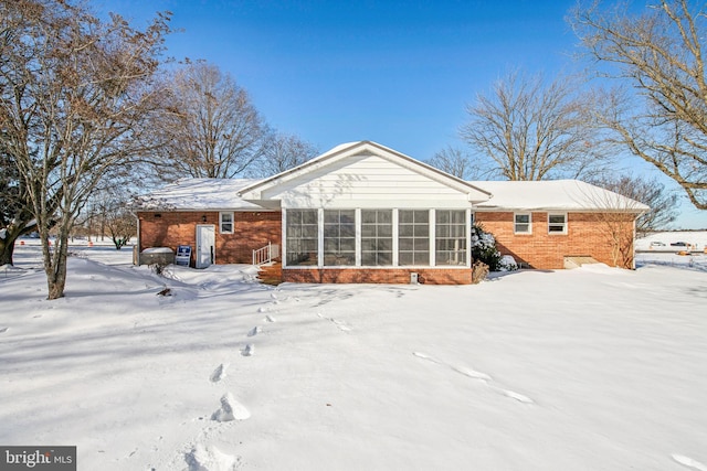 snow covered property featuring a sunroom