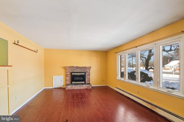 unfurnished living room with a fireplace, hardwood / wood-style flooring, and a baseboard radiator