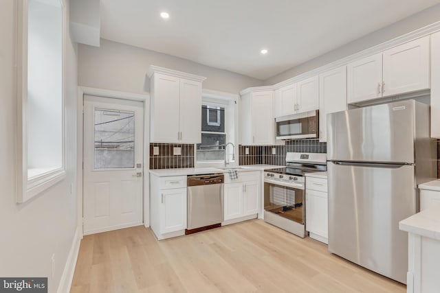 kitchen featuring tasteful backsplash, appliances with stainless steel finishes, sink, and white cabinets