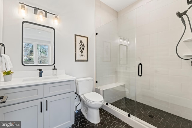 bathroom featuring vanity, tile patterned flooring, a shower with door, and toilet