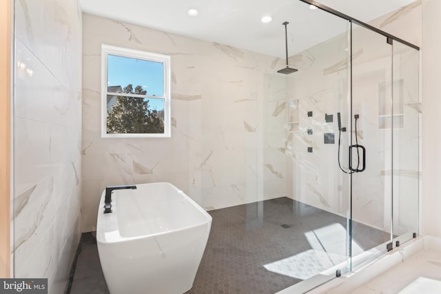 bathroom with tile walls and shower with separate bathtub