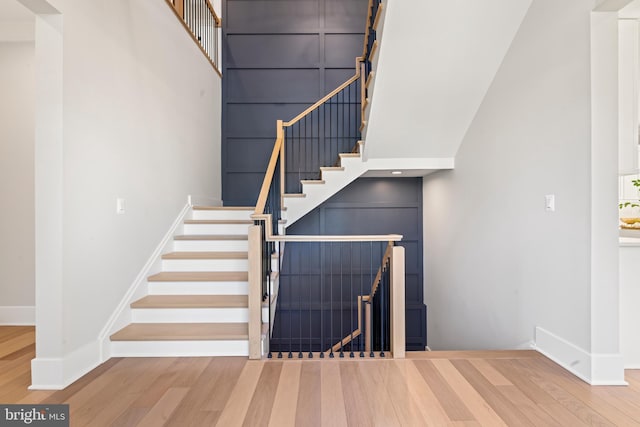 stairs with a high ceiling and wood-type flooring