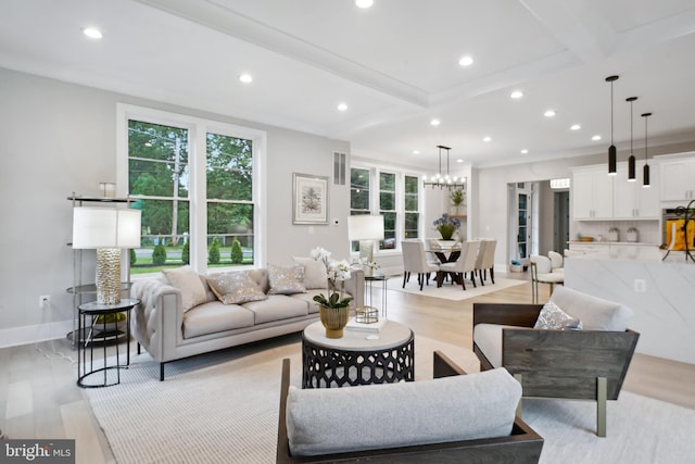 living room with ornamental molding, beam ceiling, and light hardwood / wood-style flooring