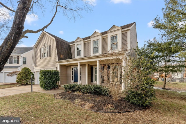 view of front of property with a garage, a front yard, and a porch