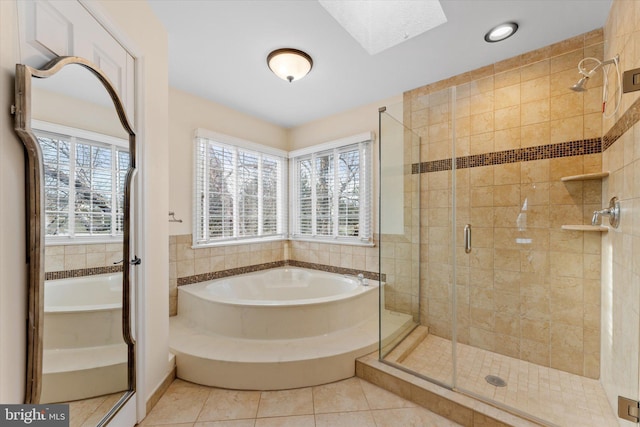 bathroom featuring separate shower and tub, tile patterned floors, and a skylight