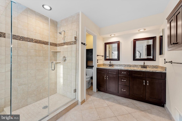 bathroom featuring walk in shower, vanity, toilet, and tile patterned flooring