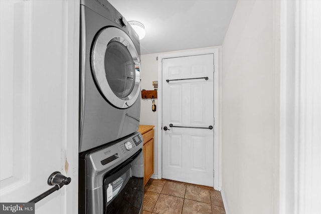 laundry room featuring stacked washer / dryer and light tile patterned floors