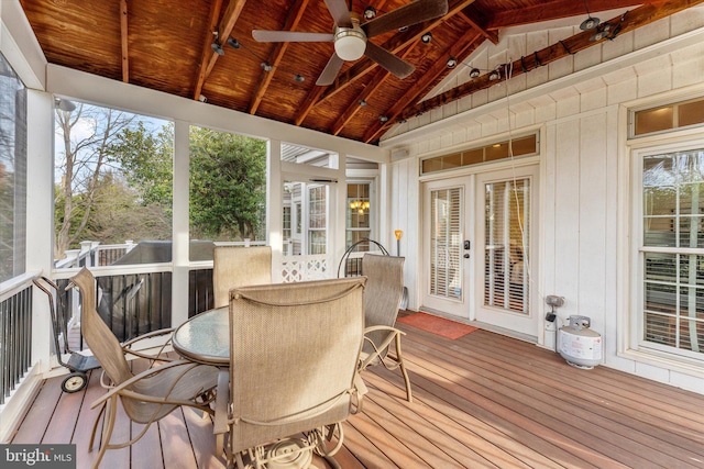 sunroom / solarium featuring ceiling fan, lofted ceiling with beams, and wooden ceiling