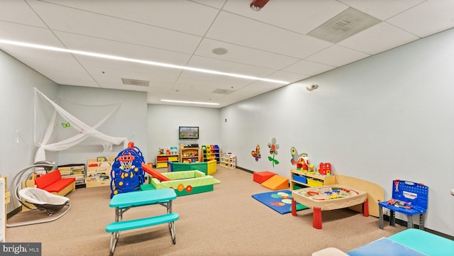 rec room featuring a paneled ceiling and carpet flooring