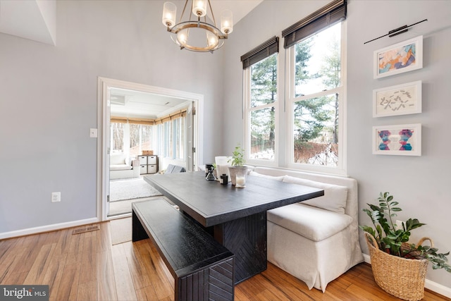 dining room with breakfast area, a chandelier, and hardwood / wood-style flooring