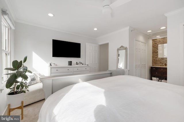 carpeted bedroom with crown molding, ensuite bath, ceiling fan, and a closet