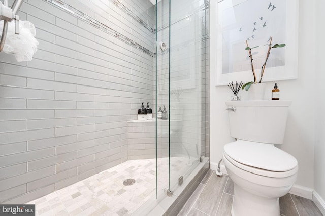 bathroom with an enclosed shower and toilet