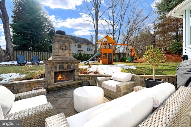 view of patio featuring an outdoor living space with a fireplace and a playground