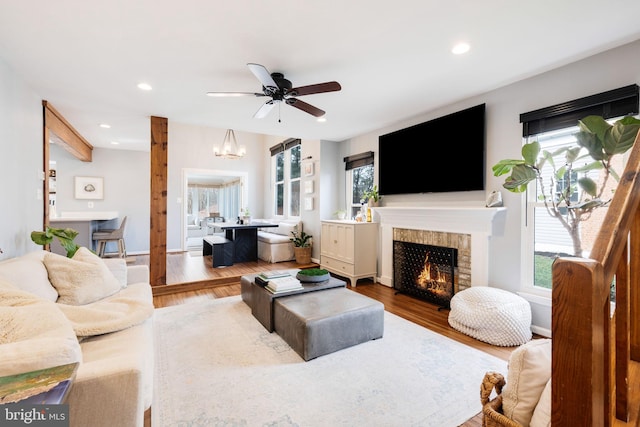 living room featuring wood-type flooring and ceiling fan with notable chandelier