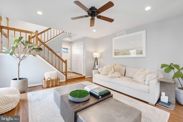 living room featuring hardwood / wood-style floors and ceiling fan