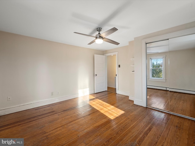 unfurnished room with ceiling fan, a baseboard radiator, and hardwood / wood-style floors