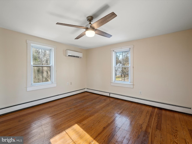 empty room with hardwood / wood-style flooring, a healthy amount of sunlight, a wall mounted air conditioner, and a baseboard radiator