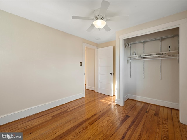 unfurnished bedroom featuring hardwood / wood-style flooring, a closet, and ceiling fan