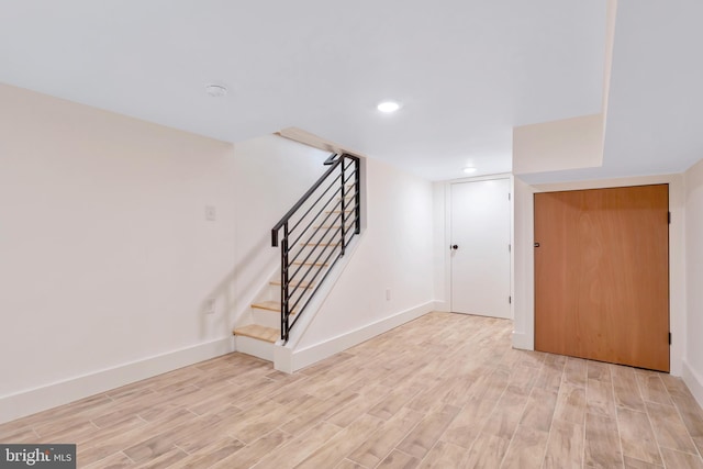 basement with light hardwood / wood-style flooring