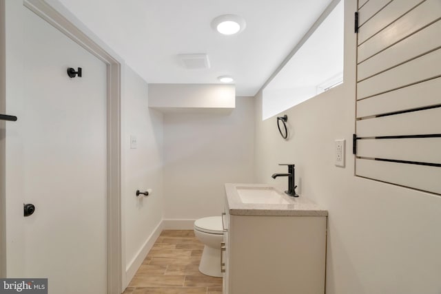 bathroom with hardwood / wood-style flooring, vanity, and toilet