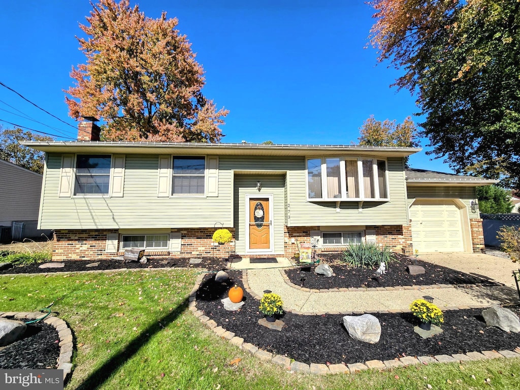 raised ranch with a garage and a front lawn