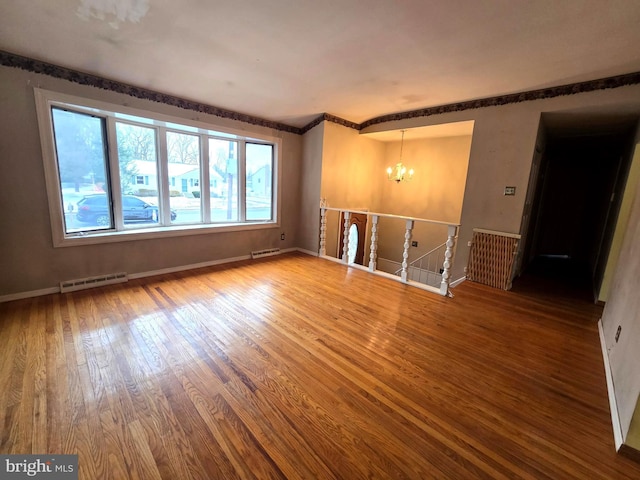 unfurnished room featuring hardwood / wood-style flooring and a chandelier