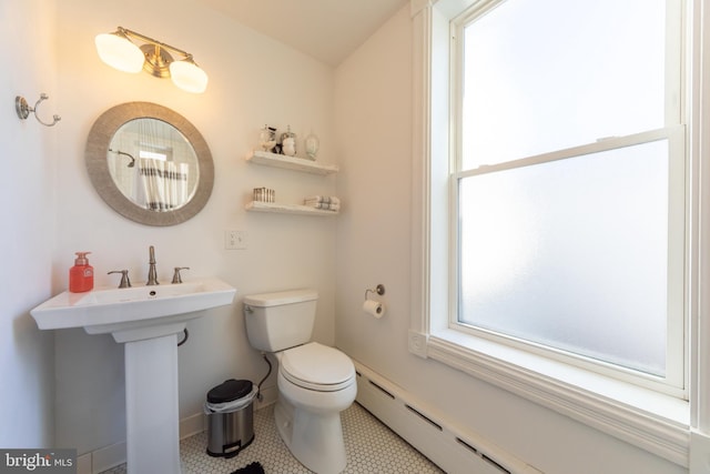 bathroom featuring sink, tile patterned floors, baseboard heating, and toilet