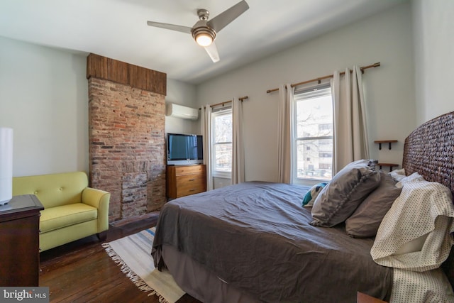 bedroom featuring dark hardwood / wood-style flooring, a wall mounted AC, and ceiling fan