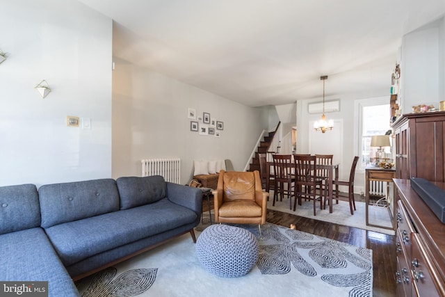 living room featuring dark wood-type flooring, radiator heating unit, and a chandelier