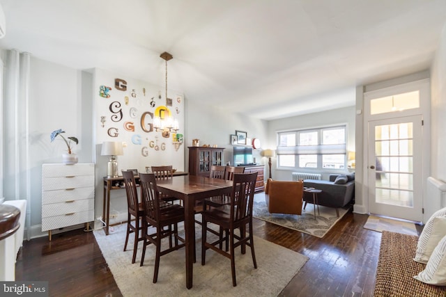 dining area with dark hardwood / wood-style flooring and radiator