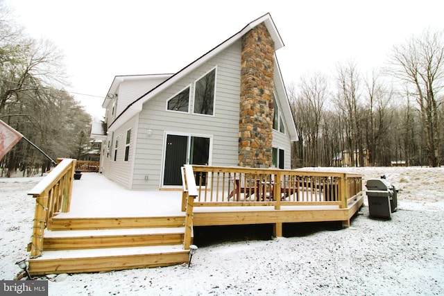 snow covered property with a deck