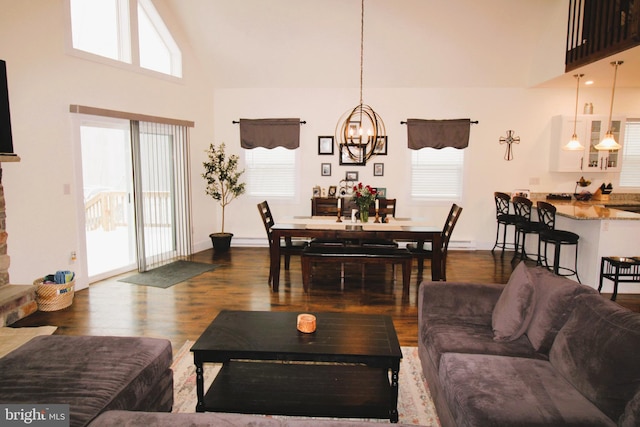 living room featuring hardwood / wood-style flooring, high vaulted ceiling, and an inviting chandelier