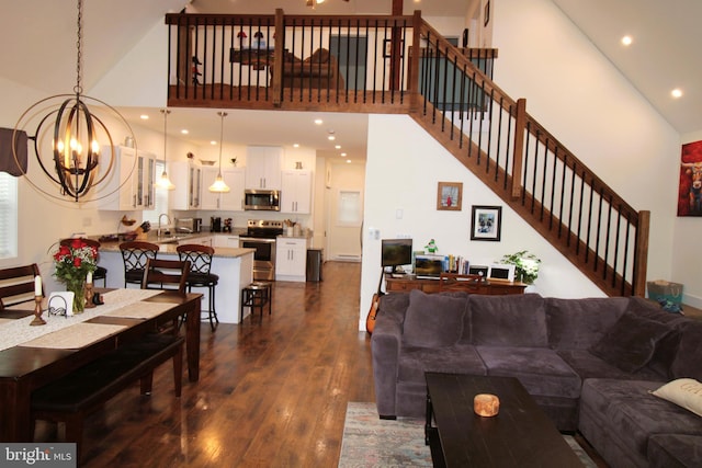 living room with sink, dark hardwood / wood-style floors, a chandelier, and high vaulted ceiling