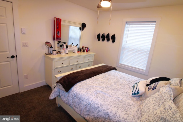 bedroom with ceiling fan and dark colored carpet