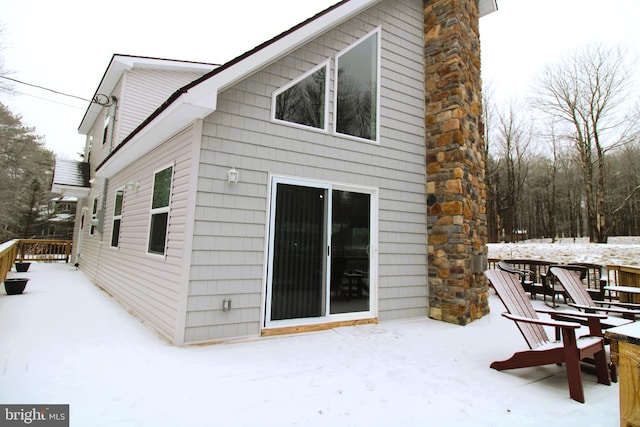 view of snow covered back of property