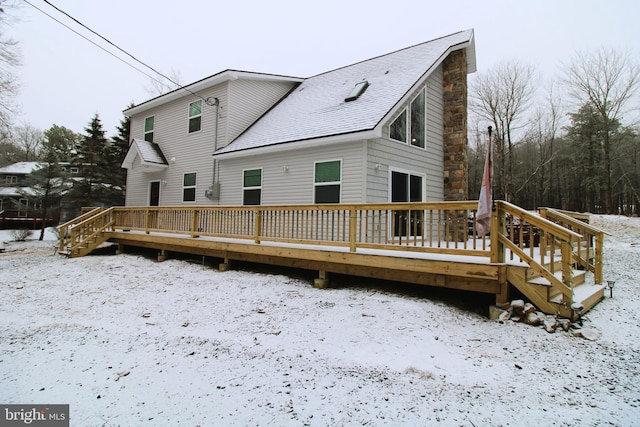 snow covered property with a wooden deck