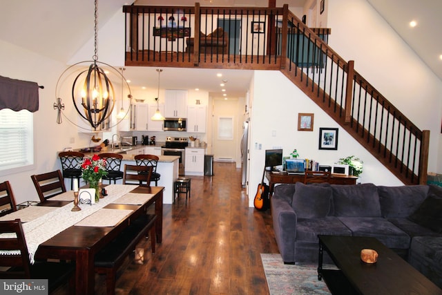 living room with an inviting chandelier, sink, high vaulted ceiling, and dark hardwood / wood-style floors