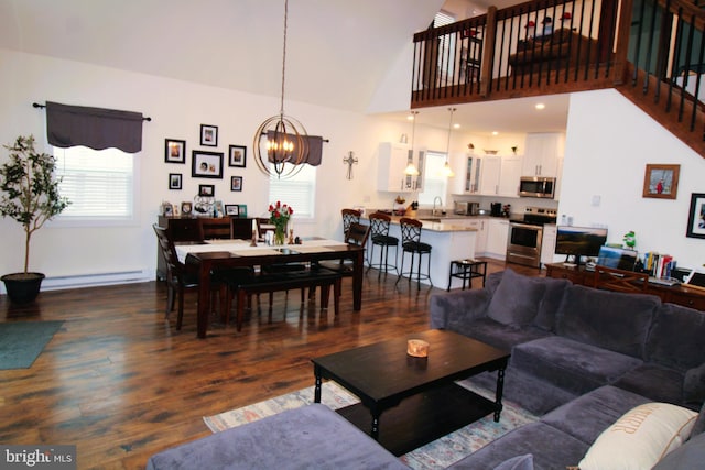 living room with an inviting chandelier, sink, plenty of natural light, and baseboard heating