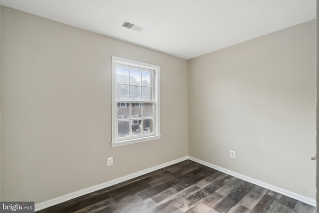 empty room with dark hardwood / wood-style flooring